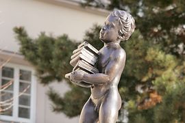 Social housing building, Sandleitenhof, statue of a boy carrying a book stack