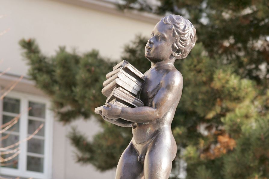Edificio de vivienda social, Sandleitenhof, estatua de un muchacho llevando una pila de libros 