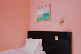 Hotel room with a pink wall and vintage interiors at Hotel am Brillantengrund 