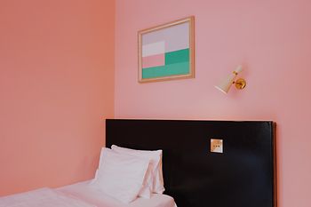 Habitación de hotel con pared rosa e interior vintage en el Hotel am Brillantengrund 