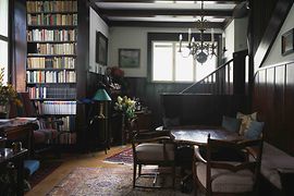 Innenansicht des Haus Steiner mit Bücherregal, Sitzecke und Treppe