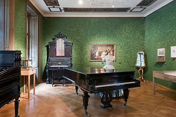 Johann Strauss Wohnung, grün tapezierter Raum mit Flügel, Orgel, Kleiderpuppe