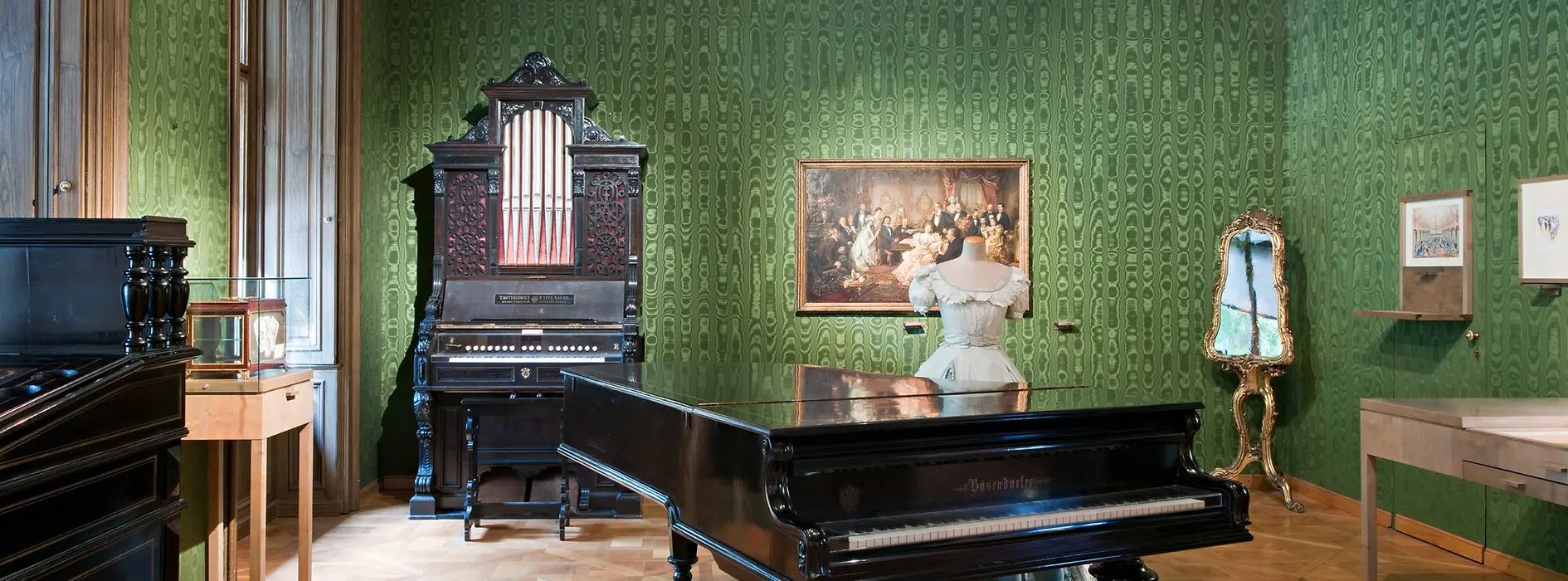 Johann Strauss Wohnung, grün tapezierter Raum mit Flügel, Orgel, Kleiderpuppe