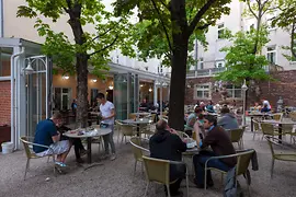 Restaurant Vincent, interior shot with a view of the outdoor dining area with guests 
