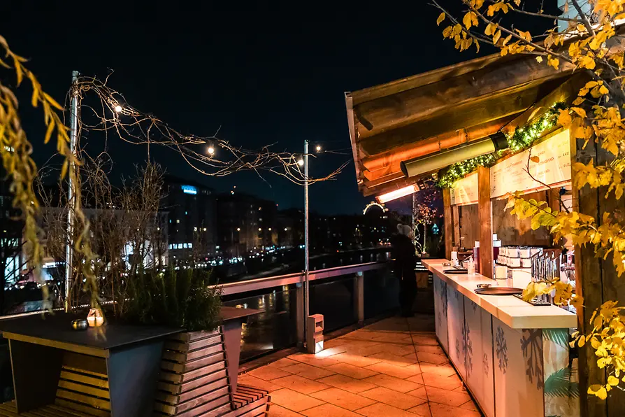 People drinking punch on a terrace with a view of the Danube Canal