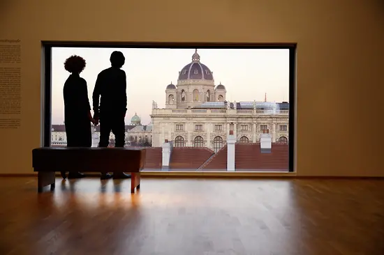 2 Personen vor einem Panoramafenster mt Aussicht auf das Kunsthistorische Museum