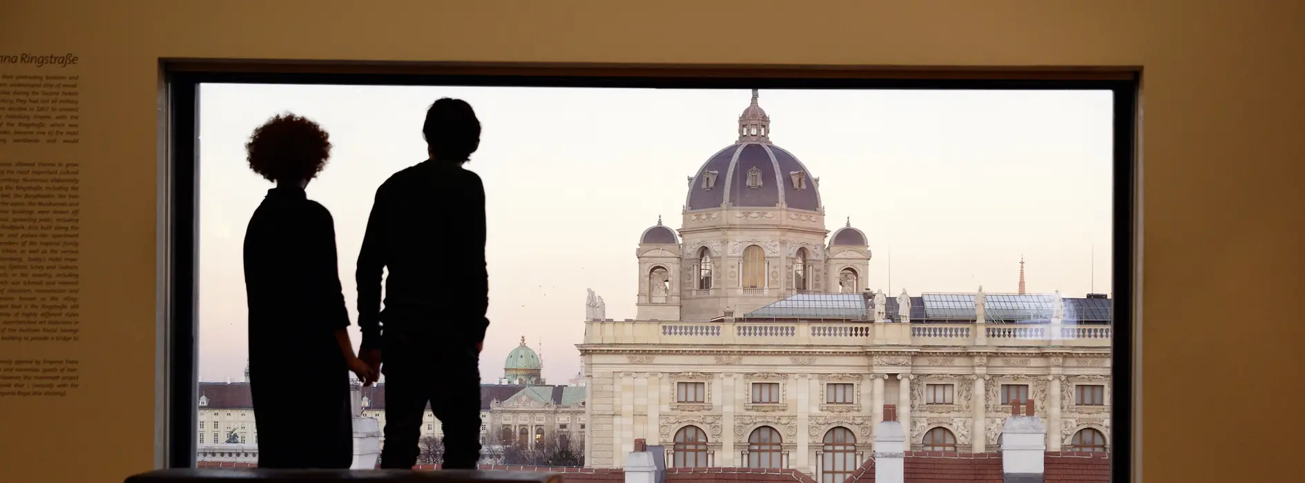 2 people in front of a big window looking at the Kunsthistorische Museum