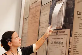 女性が古いポスターを見ている