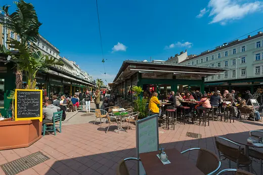 Débordement d'animation dans les établissements du Naschmarkt, vue extérieure avec personnes 