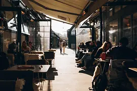 Ресторан Neni на рынке Нашмаркт, интерьер с гостями и видом наружу 