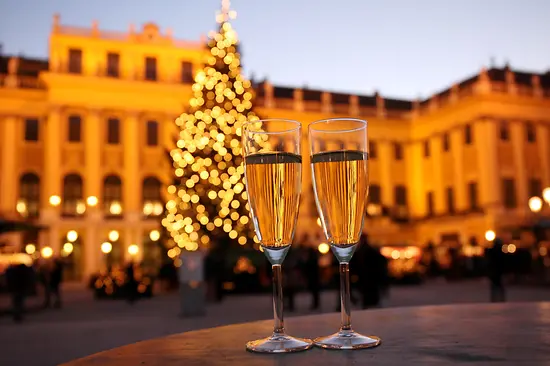 Two champagne glasses with Schönbrunn Palace in the background 