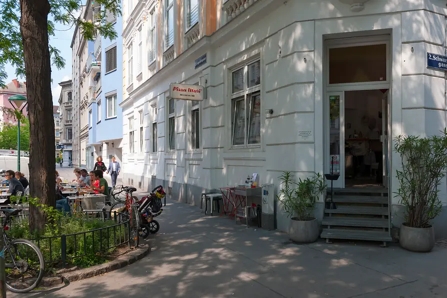Pizza Mari in the Karmeliter district, exterior shot with guests in the outdoor dining area 