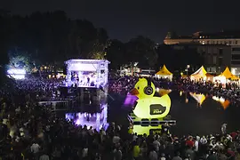 Popfest 2016: concert at night, crowd and stage outdoor with small lake, tents