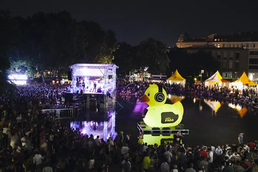 Popfest 2016: Publikum vor beleuchteter Seebühne, wo eine Band spielt. Blick auf das Gelände von oben.