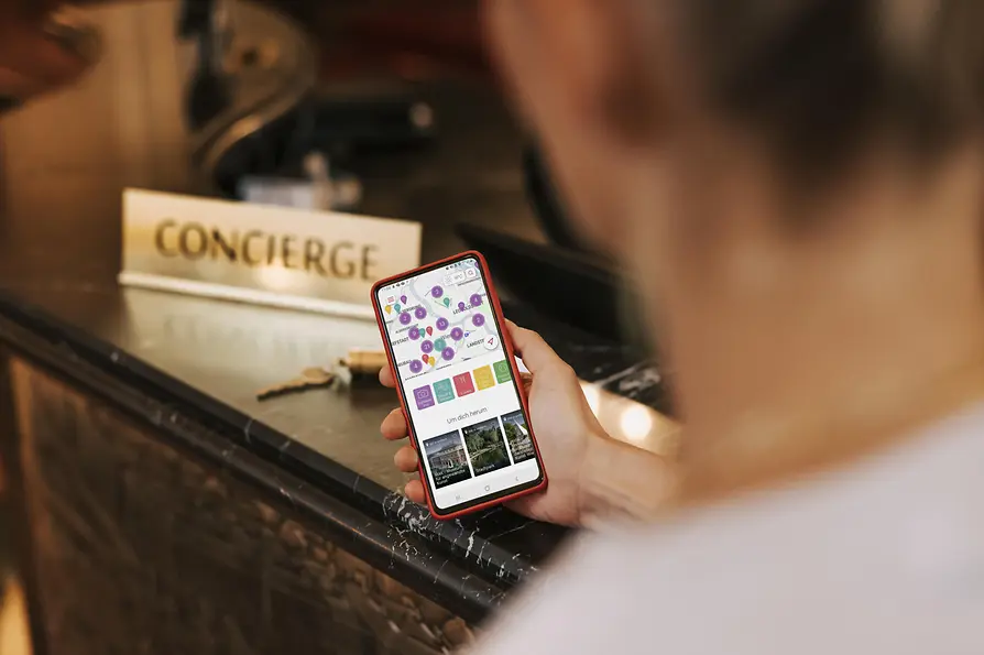 Un hombre está delante de la recepción, con la aplicación ivie abierta en su móvil