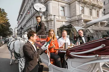 People riding in a horse-drawn carriage in Vienna
