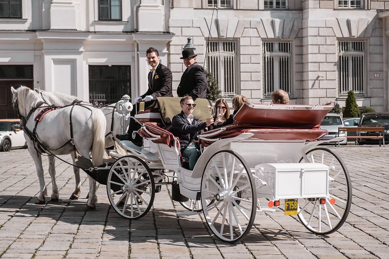 People riding in a horse-drawn carriage in Vienna