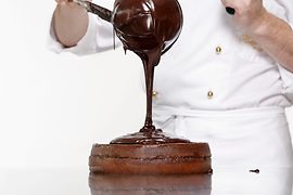 La torta Sacher viene ricoperta di glassa al cioccolato