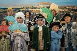 Schloss Schönbrunn erleben, Kindermuseum, Kinder verkleidet mit Perücken und Kostümen vor altem Wien-Bild