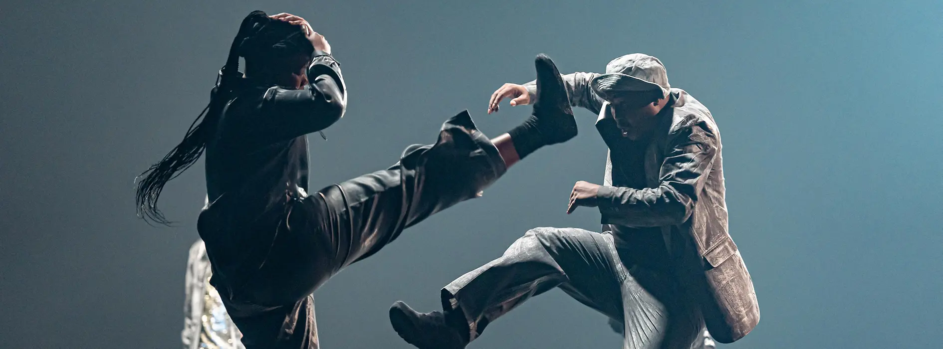 Mette Ingvartsen: Rush. A dancer wrapped in metal foil leans on a white table.