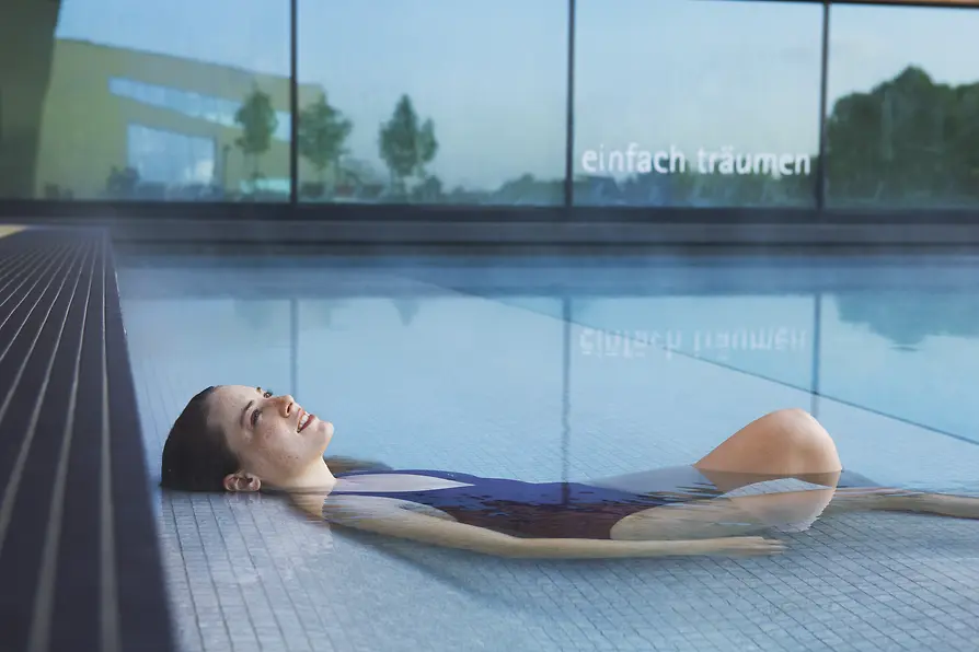 Woman relaxing in the waters of Therme Wien, Vienna's thermal baths