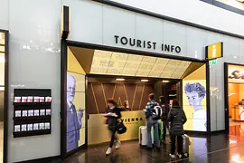 Tourist-Info am Flughafen Wien mit Reisenden im Vordergrund