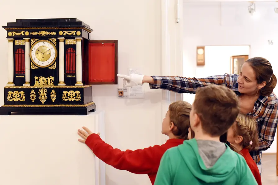 Children looking at an antique clock