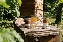 Jars of honey on a wooden table in a garden