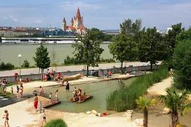 Plage de sable, palmiers et enfants sur un radeau au parc aquatique de l'Île du Danube.