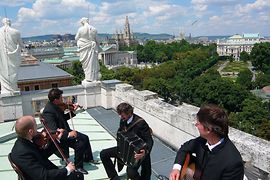 Wiener Concert Schrammeln en un tejado con Viena de fondo