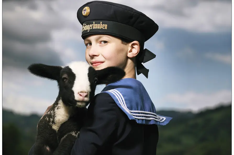 Člen Vídeňského chlapeckého pěveckého sboru Wiener Sängerknaben s jehnětem
