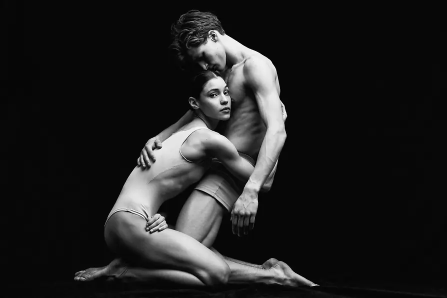 Danseuse et danseur de ballet agenouillés au sol et étroitement enlacés