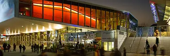 Wiener Stadthalle, abends mit Lichtern in gelb und rot, Besucher