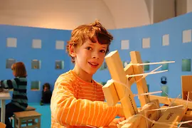 Bambino con tavolette di legno e fascette stringicavo