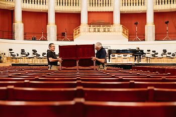Wolfgang Becker y Franz Risavy, carpinteros de la Konzerthaus de Viena, levantan un banco del Gran Salón