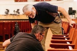 Wolfgang Becker and Franz Risavy, carpenters at the Vienna Konzerthaus, in the Great Hall, repairing seats