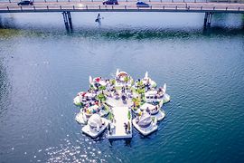 Schwimmende Inseln auf der alten Donau beim Floating Concert mit Brücke im Hintergrund 