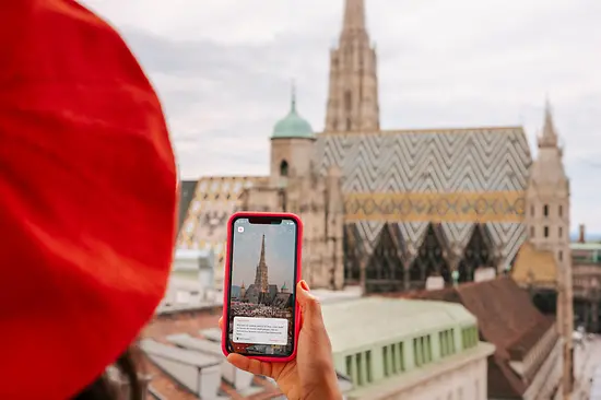 Žena s chytrým telefonem a katedrálou svatého Štěpána na pozadí