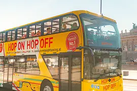 ヴィエナ・サイトシーイング・ツアーズの黄色いホップオンホップオフ ダブルデッカーに乗り込む人々