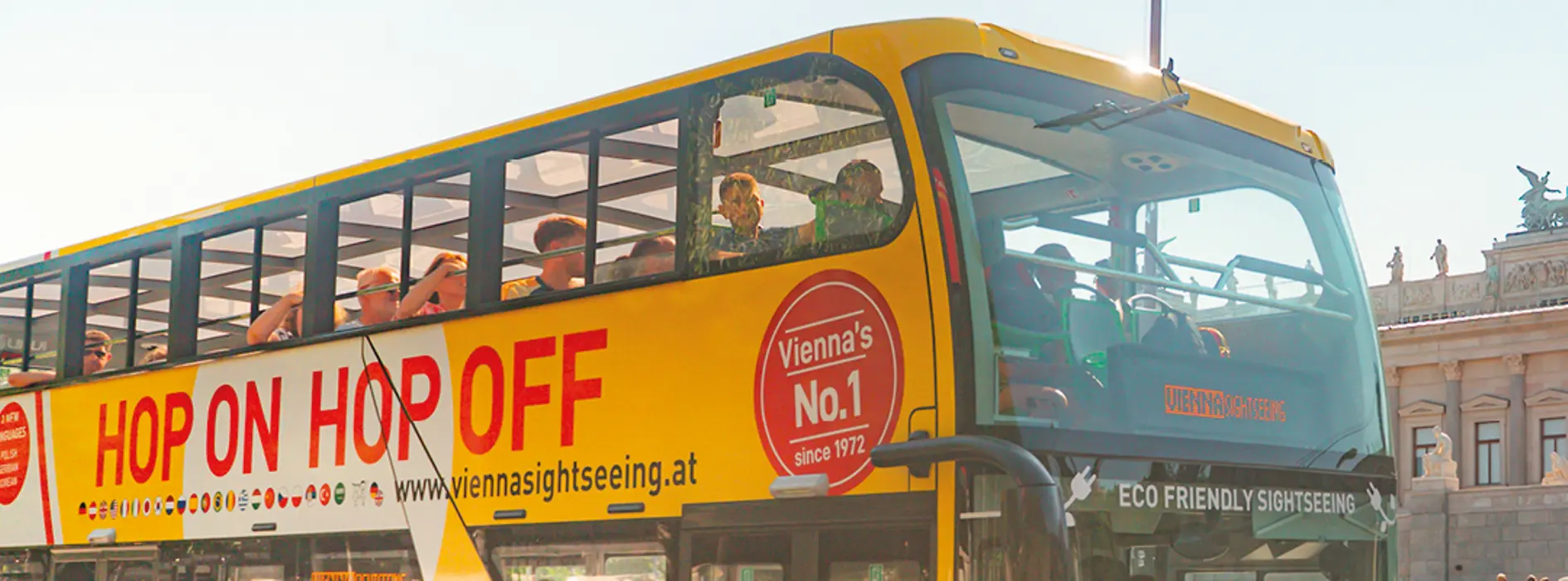 Several people getting on a yellow Hop-On Hop-Off double-decker bus of Vienna Sightseeing Tours