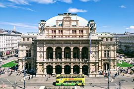 autobus giallo Hop-On Hop-Off della linea Vienna Sightseeing Tours davanti al Teatro dell'Opera di Stato