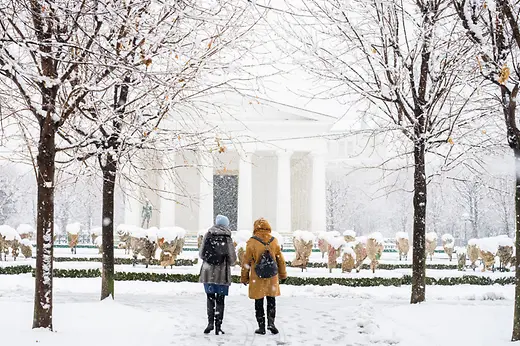 Volksgarten di Vienna: passeggiatrici nella neve davanti al Tempio di Teseo