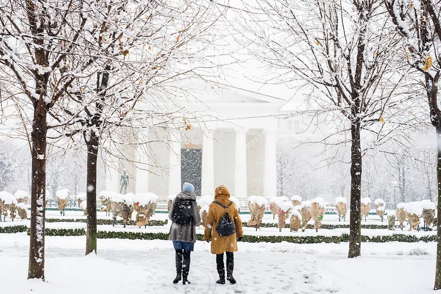 Volksgarten di Vienna: passeggiatrici nella neve davanti al Tempio di Teseo