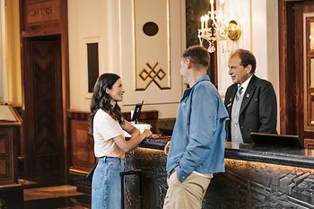 Hotelrezeption: Gäste und Rezeptionist