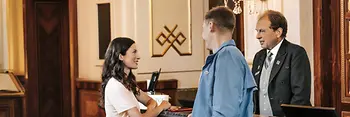 Recepcja hotelu: goście i recepcjonista