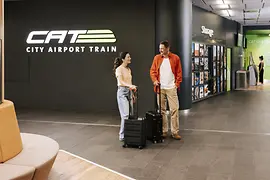 Couple avec valises au terminal CAT Wien Mitte 