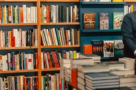 Scaffali e tavoli pieni di libri nella libreria LGBT Löwenherz