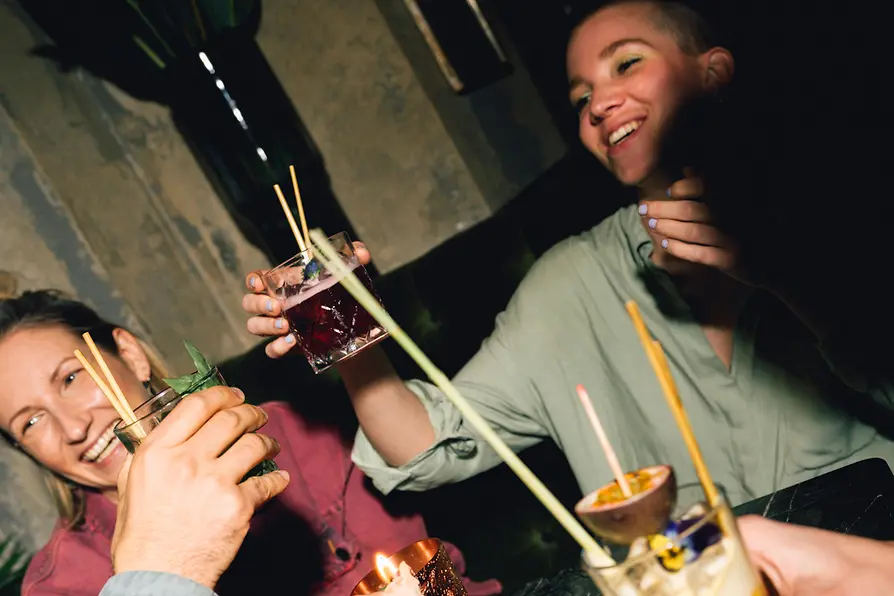 Four people with drinks at a table with candle