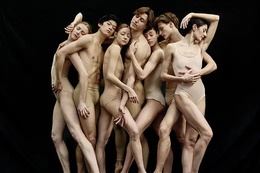 Sept danseurs et danseuses de ballet posant côte à côte.