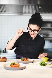 Eine Frau mit vegetarischen Gerichten am Tisch